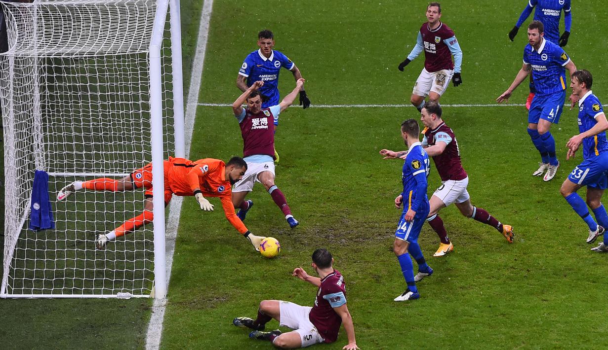 Penjaga gawang Brighton, Robert Sanchez tak gentar menghentikan bola dari serangan sejumlah pemain Burnley. (Foto: AFP/Pool/Laurence Griffiths)