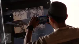 Warga memotret arsip foto kunjungan kunjungan Presiden Soekarno yang dipamerkan di area Masjid Istiqlal di Jakarta, Jumat (24/2). Pameran ini untuk memeriahkan Milad Masjid Istiqlal dan berlangsung hingga 27 Februari. (Liputan6.com/Helmi Fithriansyah)