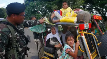 Warga yang mengungsi dari kota Marawi diperiksa tentara di kota Bal-oi, Filipina selatan (26/5). Sebelumnya, aksi kekerasan meletus di Marawi setelah sebuah serangan kelompok militan berhasil digagalkan oleh pasukan keamanan. (AP Photo / Bullit Marquez)