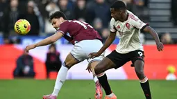 Pemain Liverpool, Alexander Isak (kanan) berebut bola dengan pemain West Ham, Konstantinos Mavropanos dalam laga Liga Inggris 2025/2026 di London Stadium, London, Inggris, Minggu (30/11/2025) waktu setempat. (AFP/Ben Stansall)