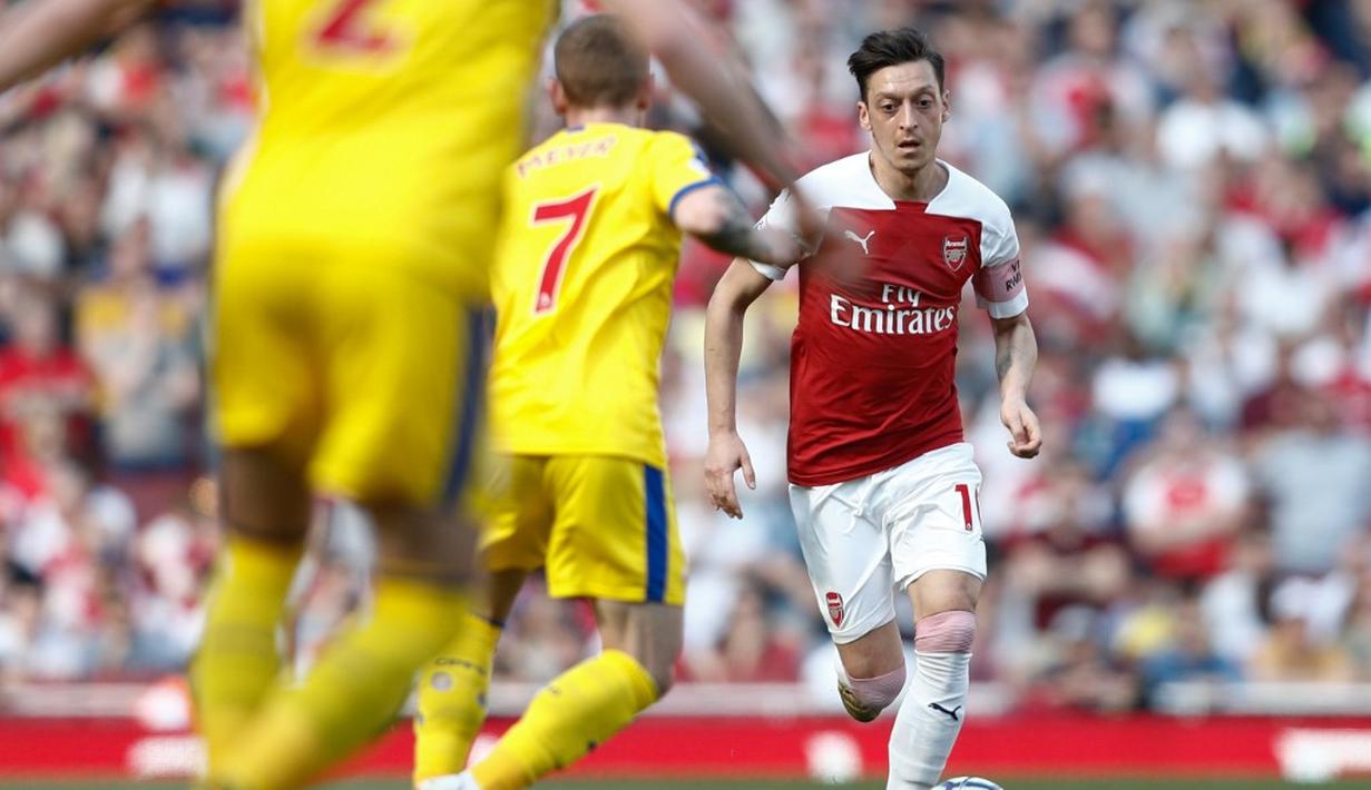 Aksi gelandang Arsenal, Mesut Ozil pada laga lanjutan Premier League yang berlangsung di Stadion Emirates, Minggu (21/4). Arsenal kalah 2-3 kontra Crystal Palace. (AFP/Adrian Dennis)