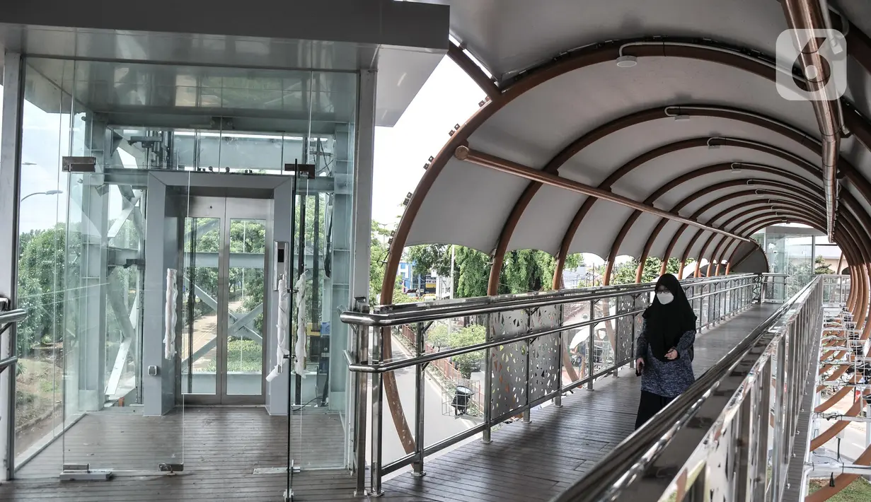 Pejalan kaki menggunakan fasilitas jembatan penyeberangan orang (JPO) di Jalan Kolonel Sugiono, Duren Sawit, Jakarta Timur, Senin (7/2/2022). JPO Kolonel Sugiono yang berada dekat Kanal Banjir Timur itu didesain dengan bentuk yang modern namun sarat kearifan lokal. (merdeka.com/Iqbal S Nugroho)