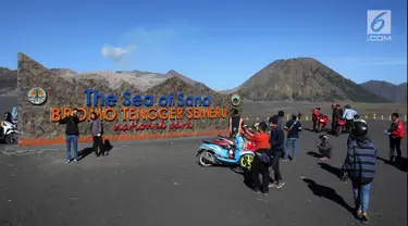Wisatawan berswafoto di Tugu Rhe Sea of Sand Bromo Tengger Semeru National Park, Probolinggo, Jawa Timur, Minggu (8/7). Gunung Bromo masih menjadi destinasi wisata primadona yang ramai dikunjungi wisatawan setiap tahunnya. (Liputan6.com/Arya Manggala)