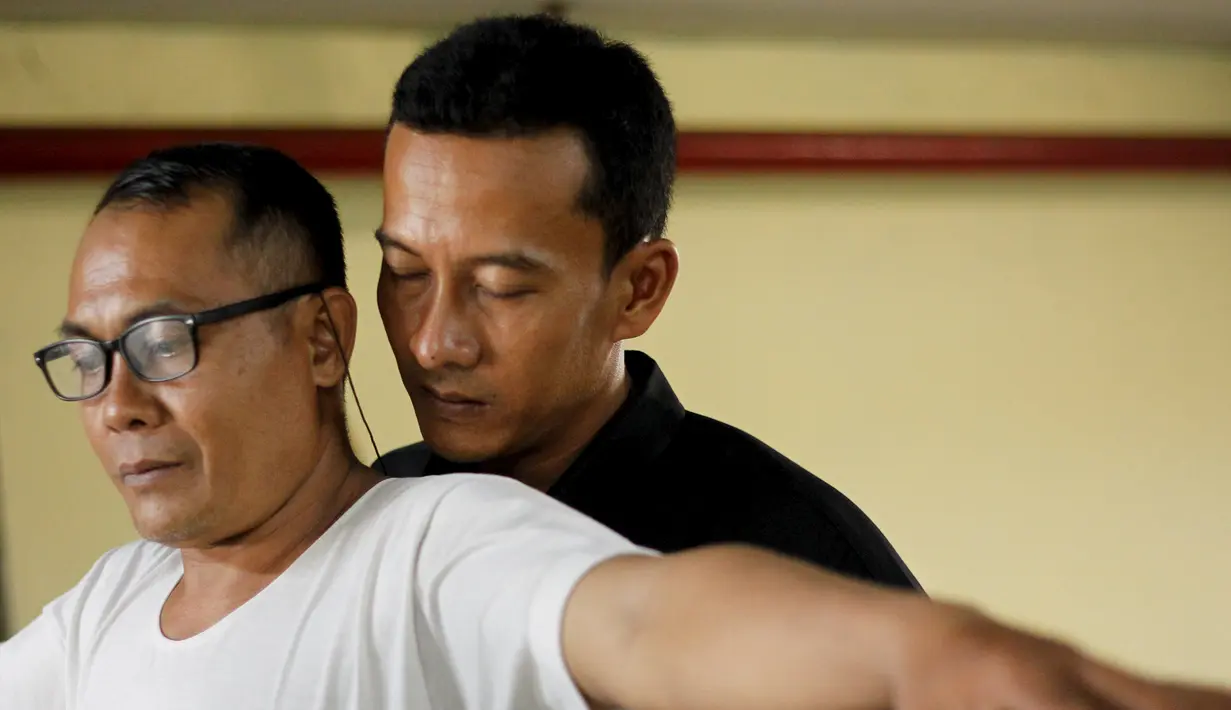 Seorang pria (kanan) melakukan tes bau badan ke salah satu calon pengemudi ojek online di sebuah tempat parkir bawah tanah di Jakarta, 9 Januari 2016. Uji bau badan ini dilakukan demi meningkatkan kualitas pelayanan. (REUTERS/Garry Lotulung)