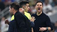 Xabi Alonso berusaha meredam aksi panas tersebut. Ia mencoba menahan dan menenangkan pemainnya, Vinicius Jr. (AFP/Fadel Senna)
