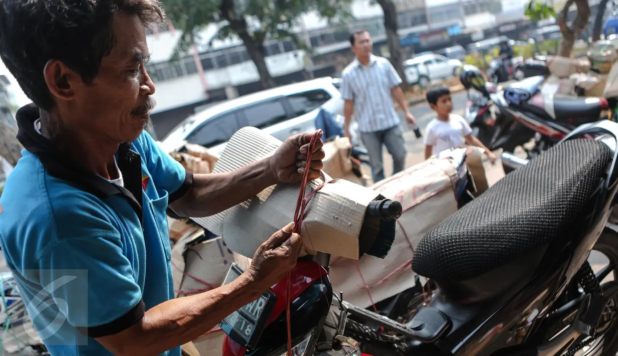 Seorang pekerja tampak mengamankan motor saat akan dikirim via kereta api, Senen, Jakarta, Senin (29/6/2015). Menjelang Hari Raya Idul Fitri 2015, pengiriman terutama untuk motor mengalami peningkatan. (Liputan6.com/Faizal Fanani)