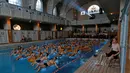 Pengunjung asyik menonton bioskop sambil bersantai di kolam renang pemandian umum Strasbourg selama European Fantastic Film Festival di Strasbourg, Prancis, Minggu (18/9). (REUTERS/Vincent Kessler)