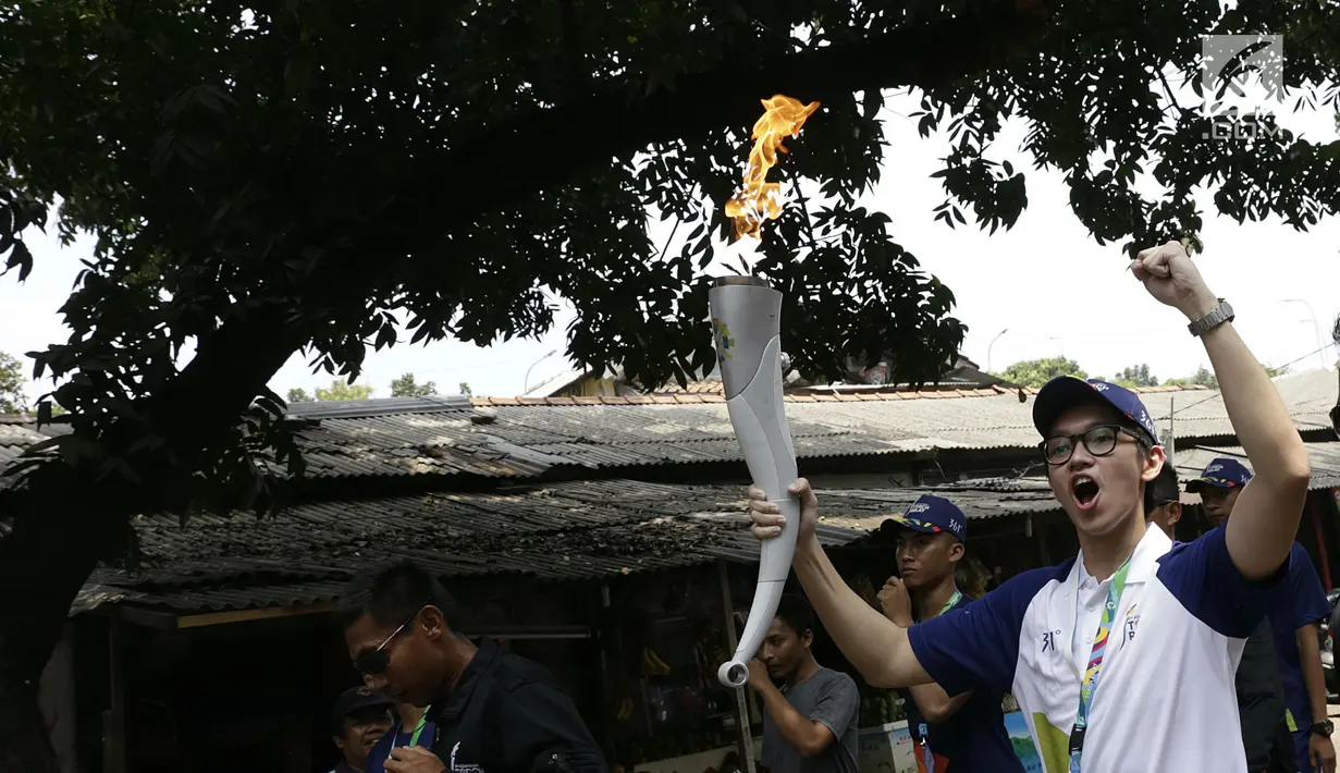Aktor Brandon Salim berlari membawa obor Asian Games saat Torch Relay Asian Games 2018 di Cipayung, Jakarta Timur, Rabu (15/8). Api Asian Games akan diarak mengelilingi 5 Kota dan 1 Kabupaten di Provinsi DKI Jakarta. (Kapanlagi.com/Agus Apriyanto)