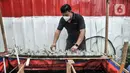 Devti (33) melakukan perawatan tanaman yang dikembangkang dengan sistem akuatik atau menggunakan air kolam ikan di kolam budi daya ikan Samawa Fish, Pondok Kelapa, Jakarta, Selasa (15/2/2022). (merdeka.com/Iqbal S. Nugroho)