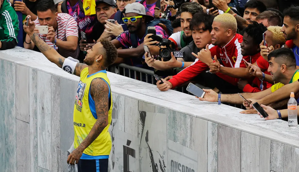 Bintang sepak bola Brasil, Neymar berswafoto dengan para penonton saat turnamen untuk badan amal Neymar Junior Project Institute di Praia Grande, Sao Paulo, Brasil, Sabtu (21/7). (AP Photo/Nelson Antoine)
