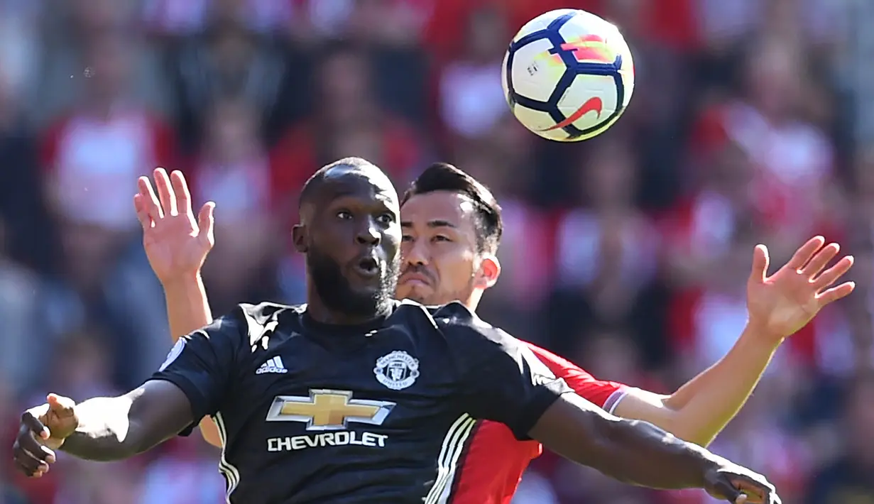 Striker Manchester United, Romelu Lukaku, duel udara dengan bek Southampton, Maya Yoshida, pada laga Premier League di Stadion St Mary's, Sabtu (23/9/2017). Manchester United menang 1-0 atas Southampton. (AFP/Glyn Kirk)