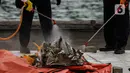 Petugas menyemprotkan disinfektan serpihan pesawat Sriwijaya Air SJ-182 yang jatuh di perairan Pulau Seribu, di Dermaga JICT, Jakarta, Selasa (12/1/2021). Petugas gabungan juga menyerahkan satu kantong perlengkapan pribadi korban. (Liputan6.com/Johan Tallo)