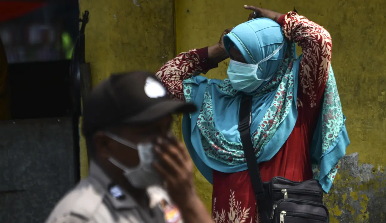 Seorang warga memakai masker yang diberikan petugas polisi saat kabut asap tebal menyelimuti wilayah di Banda Aceh (25/9/2019). PBB memperingatkan pada 24 September, ketika para ilmuwan mengatakan api melepaskan sejumlah besar gas rumah kaca yang merusak iklim. (AFP Photo/Chaideer Mahyuddin)