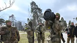 Anggota Pasukan Pertahanan Teritorial Ukraina memeriksa senjata anti-tank NLAW di tengah invasi Rusia yang sedang berlangsung ke Ukraina di Kiev (9/3/2022). (AFP/Genya Savilov)