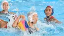 Pemain Jepang, Marina Tokumoto (tengah) memperjuangkan bola saat melawan Indonesia dalam babak penyisihan polo air putri Grup A Asian Games 2018 di Jakarta, Kamis (16/8). Indonesia kalah 4-15. (PETER PARKS/AFP)