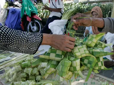 Pedagang kulit ketupat melayani pembeli di sekitar Pakualaman,Yogyakarta, menjelang Hari Raya Idul Fitri 1437 Hijriah, Senin (4/7). H-2 menjelang Lebaran, pedagang musiman yang menjual kulit ketupat mulai bermunculan. (Liputan6.com/Boy Harjanto)