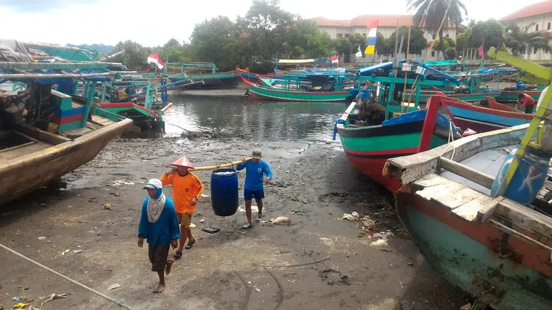 Nelayan Cilacap memikul ikan usai melaut. (Foto: Liputan6.com/Muhamad Ridlo)