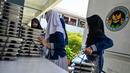 Para siswa mengambil nampan berisi makanan yang dipasok oleh program Makan Bergizi Gratis (MBG) di sebuah sekolah dasar di Banda Aceh pada Kamis 30 Oktober 2025. Program ini melibatkan berbagai pihak dan dilaksanakan secara bertahap. (CHAIDEER MAHYUDDIN/AFP)
