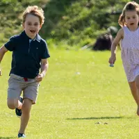 Pangeran George dan Putri Charlotte berlarian di atas rumput saat menghadiri acara amal Maserati Royal Charity Polo Trophy untuk mendukung sang ayah, Pangeran William yang bertanding di Beaufort Polo Club, Gloucestershire, Minggu (10/6). (AP Photo)