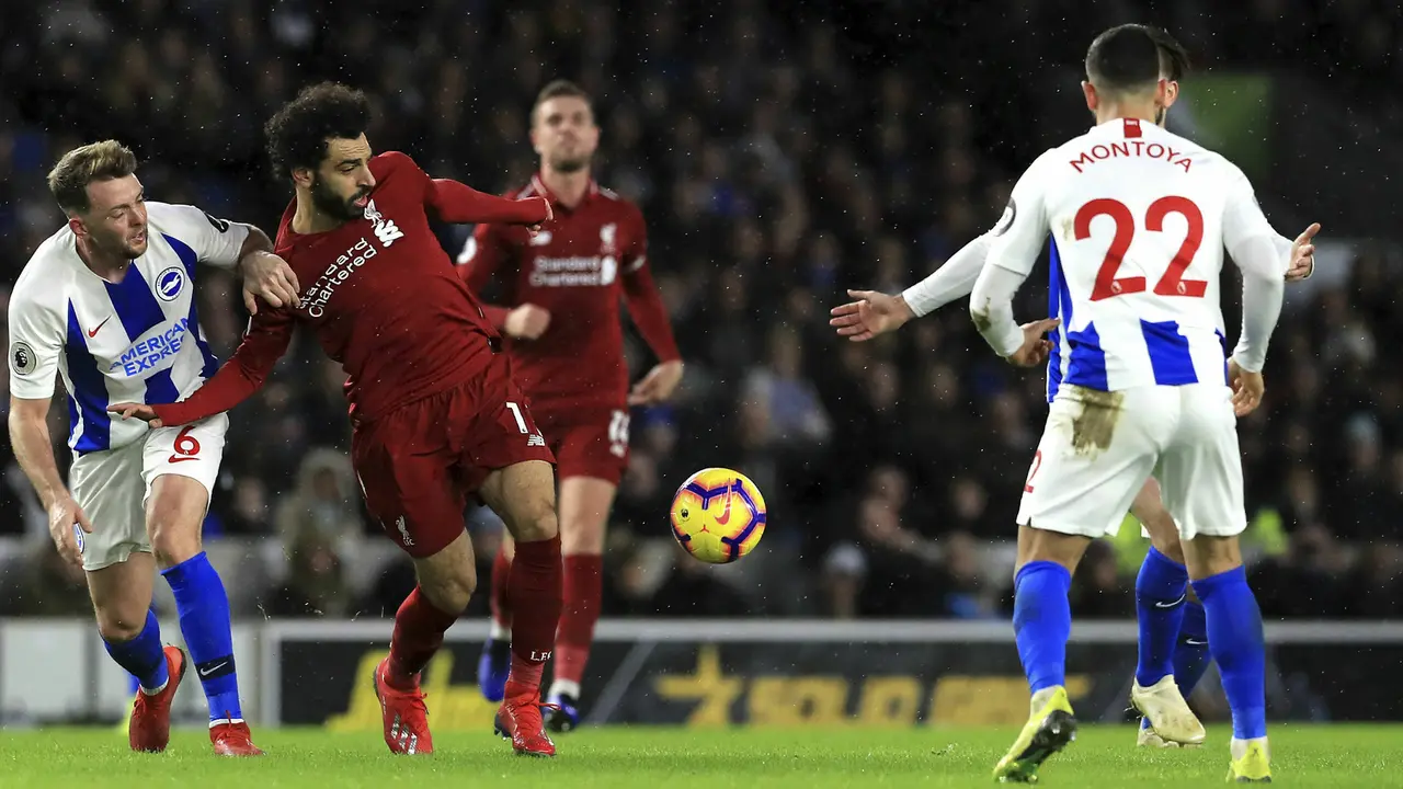 Gelandang Brighton, Dale Stephens, berebut bola dengan gelandang Liverpool, Mohamed Salah. (AP/Gareth Fuller)