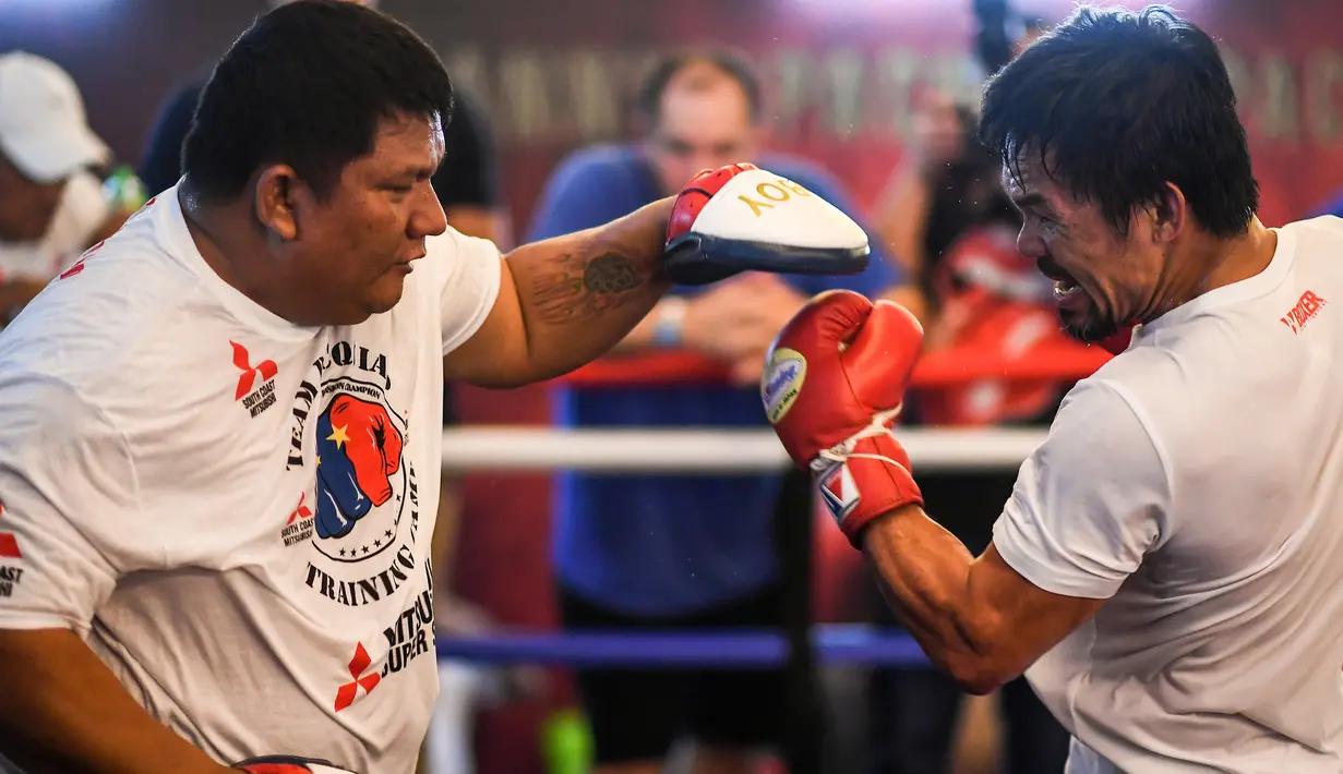 Petinju asal Filipina, Manny Pacquiao (kanan) berlatih selama sesi pelatihannya di sebuah gym di Kuala Lumpur, Malaysia (11/7). Manny Pacquiao dan Lucas Matthysse akan bertanding pada 15 Juli 2018. (AFP Photo/Mohd Rasfan)