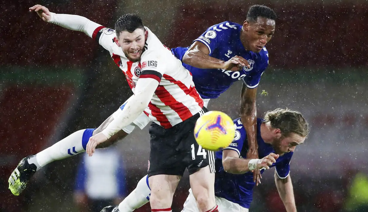 Pemain Everton, Tom Davies dan Yerry Mina, duel udara dengan pemain Sheffield United, Oliver Burke, pada laga Liga Inggris di Stadion Bramall Lane, Sabtu (26/12/2020). Everton menang dengan skor 1-0. (Nick Potts/Pool via AP)