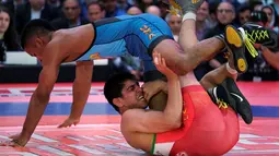Pegulat dari AS, Mark Hall (biru) melawan Ahmad Bazrighaleh dari Iran pada Beat the Streets, Times Square, New York (19/5).Gelaran pertandingan gulat yang dibuat oleh Mike Novogratz ini merupakan salah satu pengumpulan dana. (REUTERS/Adrees Latif)