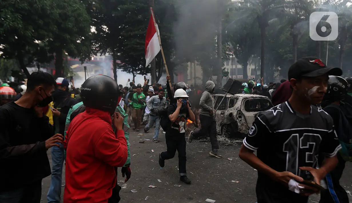 Massa yang berunjuk rasa berlarian meninggalkan kawasan sekitar Markas Komando (Mako) Korps Brigade Mobil (Brimob) Polda Metro Jaya di kawasan Kwitang, Jakarta Pusat, Jumat (29/8/2025). (Liputan6.com/Helmi Fithriansyah)