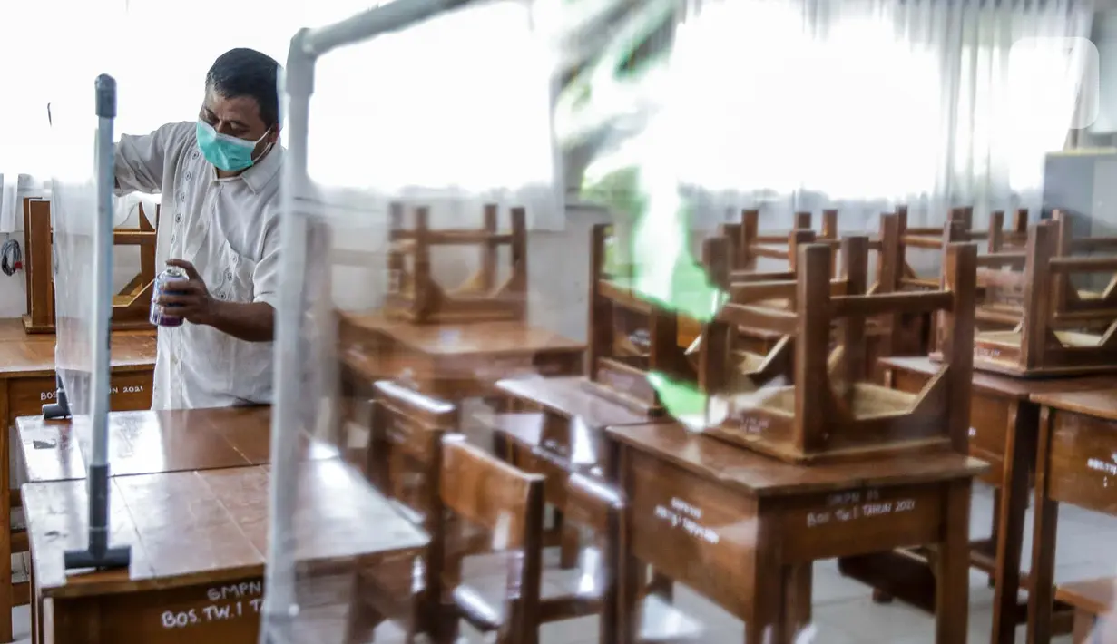 Petugas menyiapkan ruangan kelas yang akan digunakan di SMP N 115 Jakarta, Jumat (21/5/2021). Seleksi PPDB DKI Jakarta tahun ini akan dibagi menjadi empat bagian yakni jalur prestasi, jalur afirmasi, jalur zonasi, dan jalur pindah tugas orangtua dan anak guru. (Liputan6.com/Faizal Fanani)