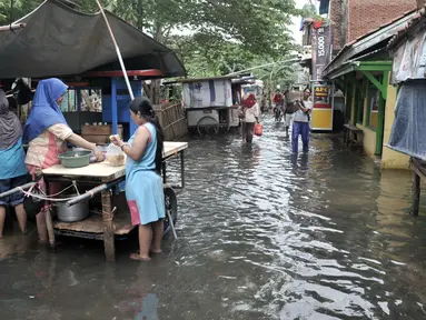 Aktivitas warga di tengah banjir yang masih merendam Kampung Rawa Indah, Jakarta Utara, Senin (24/2/2020). Kampung yang terletak di dua kelurahan, yakni Sukapura dan Pegangsaan Dua tersebut masih terendam banjir hingga sore ini dengan ketinggian air 30-50 cm. (merdeka.com/Iqbal S Nugroho)
