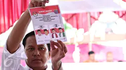 Petugas mengeluarkan surat suara para calon untuk dilakukan suara Pilkada serentak di TPS Kampung Pilkada RW 03, Depok, Jawa Barat, (9/12). (Liputan6.com/Immanuel Antonius)