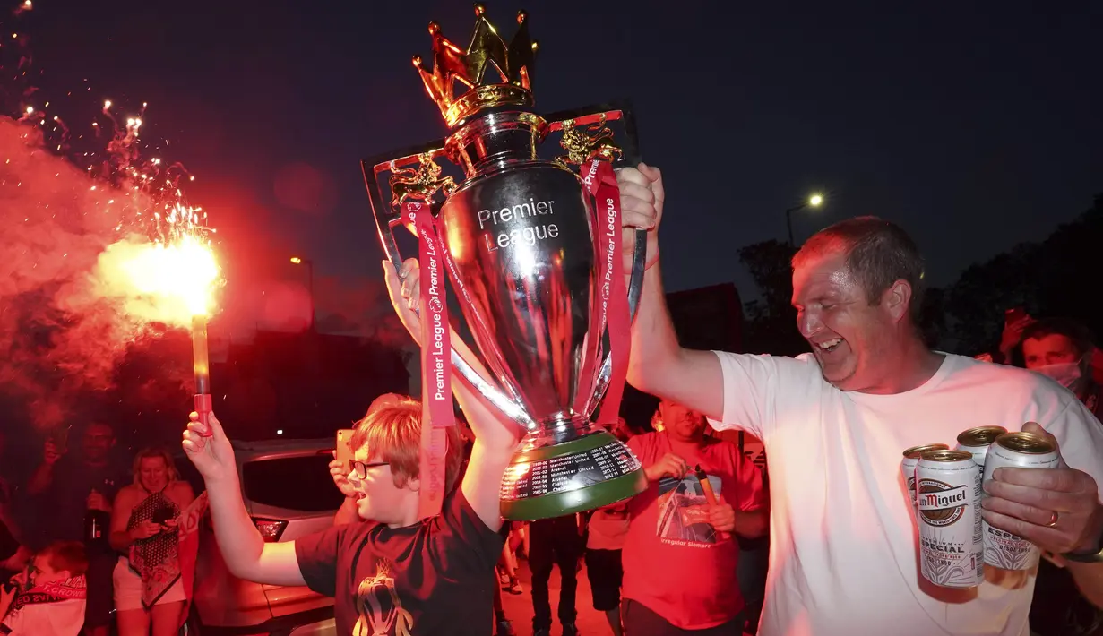 Suporter Liverpool merayakan gelar juara Premier League di depan Stadion Anfield, Kamis (25/6/2020). Titel juara Liga Inggris 2019-20 ini merupakan gelar pertama Liverpool setelah puasa selama 30 tahun. (AP/Jon Super)