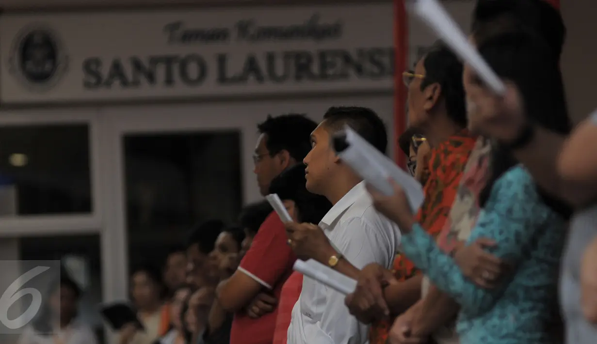Para jemaat saat melakukan ibadah di Gereja Santo Laurensius, Alam Sutra, Tangerang, Kamis (24/12). Anggota kepolisian dan TNI berjaga disekitaran gereja untuk menanggulangi hal - hal yang tidak diinginkan. (Liputan6.com/Faisal R Syam)