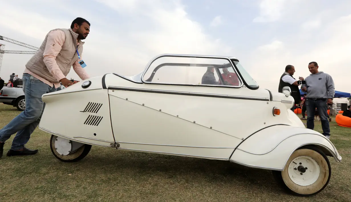 Seorang pria mendorong mobil model 'Kabinenroller' klasik Messerschmitt KR200 selama Pertemuan Klasik Kairo ke-7 di Kairo, Mesir (23/3). (Reuters/Mohamed Abd El Ghany)