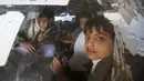 Anak - anak kelompok houthi memegang senjata selama ikuti demonstrasi di jalanan Ibukota Yaman, Sanna, Jumat, (20/11). (REUTERS/Khaled Abdullah)