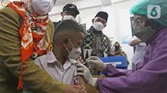 Menko PMK Muhadjir Effendy melihat petugas kesehatan menyuntikkan vaksin COVID-19 kepada siswa di SDN 01 Depok, Depok, Jawa Barat, Selasa (14/12/2021). Kunjungan tersebut untuk melihat persiapan vaksinasi COVID-19 anak usia 6-11 tahun yang dilaksanakan mulai hari ini. (Liputan6.com/Herman Zakharia)