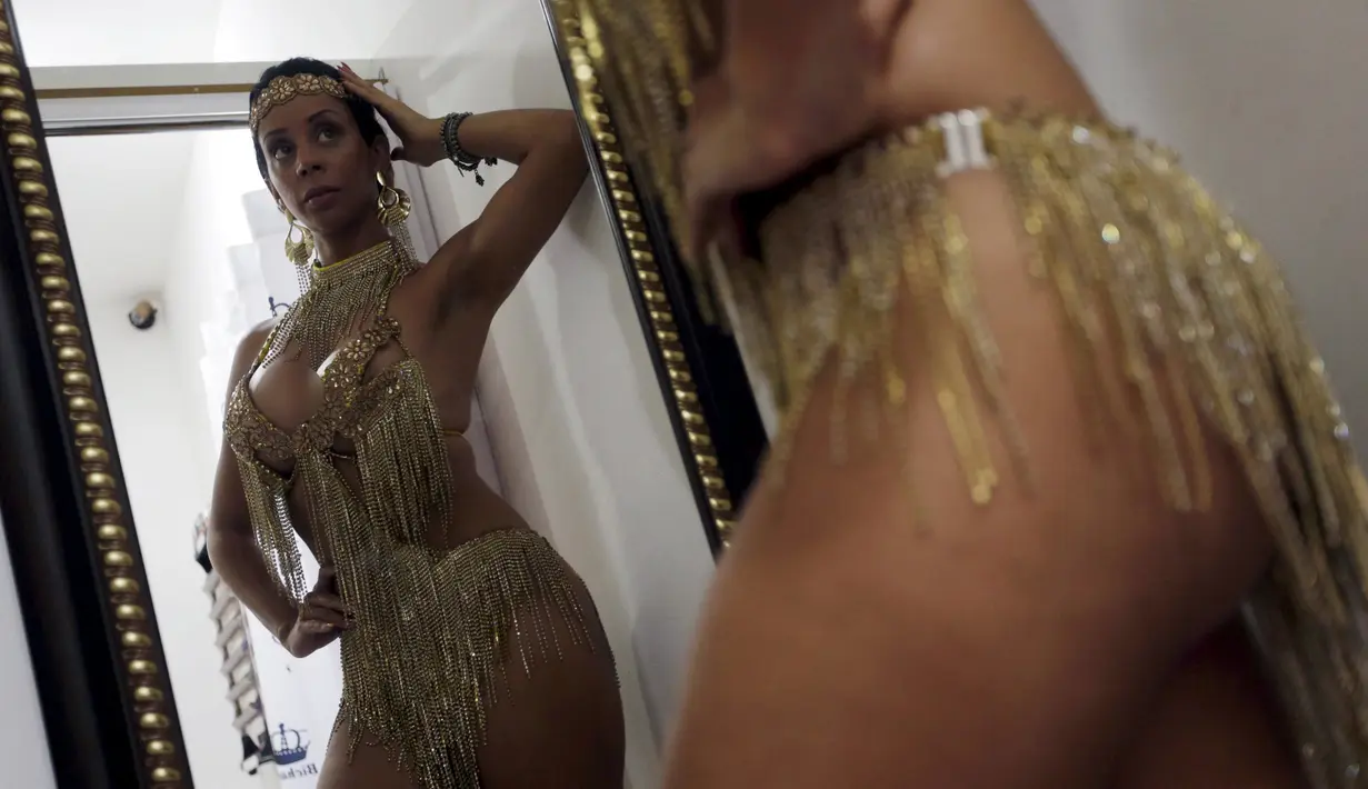 Seorang penari karnaval atau orang Brasil menyebutnya "muses", Larissa Neto saat mencoba kostum didepan kaca untuk memeriahkan karnava di Brasil, (3/2). Di Brasil menjadi seorang muses merupakan impian para gadis Brasil. (REUTERS / Ricardo Moraes)