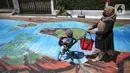 Warga melintas di atas jalan yang telah dilukis mural di Jalan Keuangan, Cilandak, Jakarta, Rabu (26/8/2020). Mural di sepanjang jalan Keuangan menuju museum Basoeki Abdullah itu bertujuan memperindah wilayah tersebut serta sebagai ajang promosi museum. (Liputan6.com/Faizal Fanani)