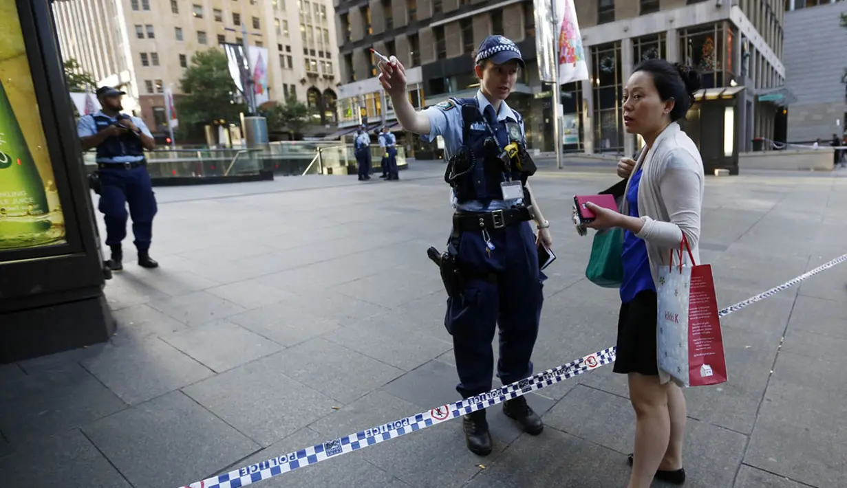 Aparat kepolisian setempat masih menutup jalan di dekat lokasi pengepungan di Kafe Lindt, Sidney, Australia (16/12/2014). Polisi berhasil membebaskan sejumlah sandera yang ditahan di Kafe Lindt. (REUTERS/Jason Reed)