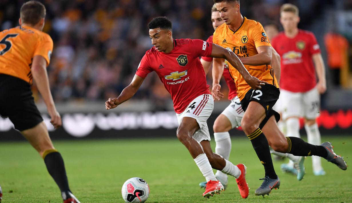 Gelandang Manchester United, Jesse Lingard, berusaha melewati bek Wolverhampton, Ryan Bennett, pada laga Premier League di Stadion Molineux, Wolverhampton, Senin (19/8). Kedua klub bermain imbang 1-1. (AFP/Paul Ellis)