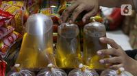 Pedagang tengah menata minyak curah yang dijual di pasar di Kota Tangerang, Banten, Kamis (25/11/2021). Pemerintah melarang peredaran minyak goreng curah ke pasar per tanggal 1 Januari 2022. (Liputan6.com/Angga Yuniar)