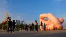 Orang-orang berjalan melewati patung "Gekrose" tahun 2011 karya mendiang seniman Austria Franz West, di corniche tepi laut Doha pada hari kedua Idul Fitri, yang menandai akhir bulan suci puasa Ramadhan. (AFP/Karim Jaafar)