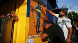 Dua orang fans tampak sedih usai meninggalnya Diego Maradona di Buenos Aires, Argentina, Rabu (25/11/2020). legenda sepak bola Argentina itu meninggal dunia pada usia 60 tahun setelah menderita serangan jantung. (AP/Natacha Pisarenko)