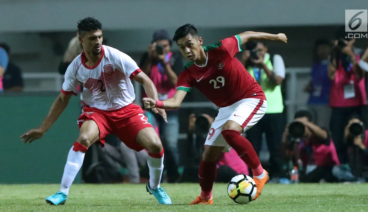 Gelandang Indonesia U-23, Septian David Maulana (kanan) berebut bola dengan bek Bahrain, Sayed Mohamed Shubbar pada laga PSSI Anniversary 2018 di Stadion Pakansari, Kab Bogor, Jumat (27/4). Indonesia kalah 0-1. (Liputan6.com/Helmi Fithriansyah)