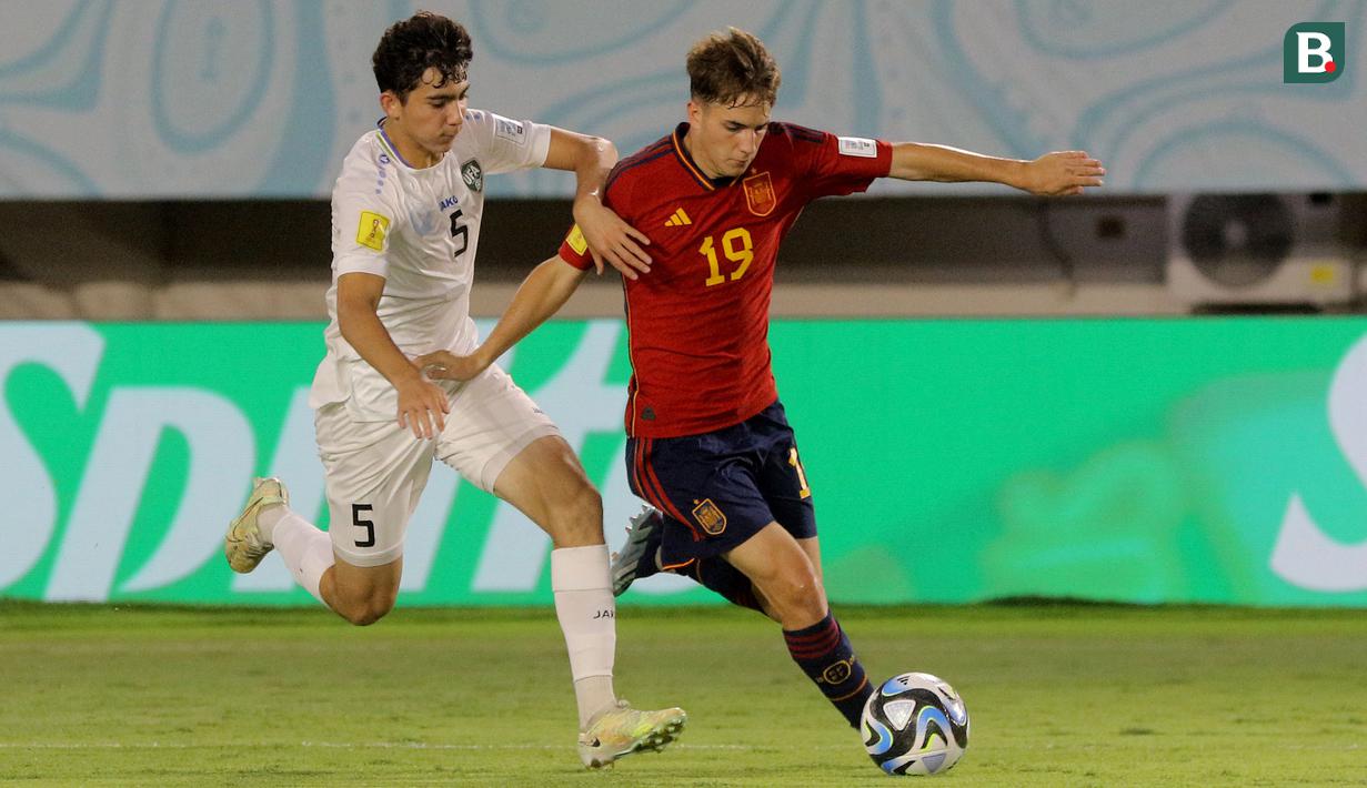 Pemain Timnas Spanyol U-17, Daniel Yanez (kanan), mengontrol bola dibayangi pemain Timnas Uzbekistan U-17, Azizbek Tulkunbekov dalam laga pamungkas Grup B Piala Dunia U-17 2023 yang berlangsung di Stadion Manahan, Solo, Kamis (16/11/2023) sore WIB. (Bola.com/Arief Bagus Prasetiyo)