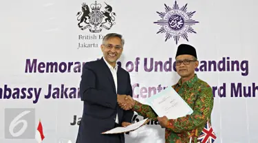 Dubes Inggris untuk Indonesia Moazzam Malik (kiri) bersama Ketua Umum PP Muhammadiyah Haedar Nasir melakukan penandatanganan nota kesepahaman di Jakarta, Senin (16/5). (Liputan6.com/Immanuel Antonius)