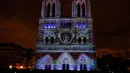 Pemandangan saat Gereja Katedral Notre-Dame de Paris dihiasi cahaya, Prancis (11/11). Pertunjukan cahaya ini dalam rangka peringatan Hari Gencatan Senjata yang menandai berakhirnya Perang Dunia I. (AFP Photo/Francois Guillot)