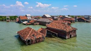 Dua faktor di atas, menyebabkan abrasi, banjir rob permanen, dan kehilangan lahan yang terus meningkat, dengan proyeksi wilayah seperti Pekalongan akan 80% di bawah permukaan laut pada 2035. Tampak dalam foto yang diambil pada 30 Juli 2025 menunjukkan pemandangan udara rumah-rumah yang terbengkalai dan sebagian terendam air akibat kehilangan lahan akibat perubahan iklim di Desa Bedono, Demak, Jawa Tengah. (BAY ISMOYO/AFP)