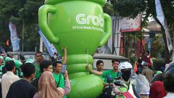 Mitra dari Grab membawa balon raksasa saat obor Asian Games XVIII melintas di Kota Malang, Jawa Timur, Jumat (20/7/2018). Sebanyak 53 kota di Indonesia akan dilalui oleh obor Asian Games. (Bola.com/Aditya Wani)