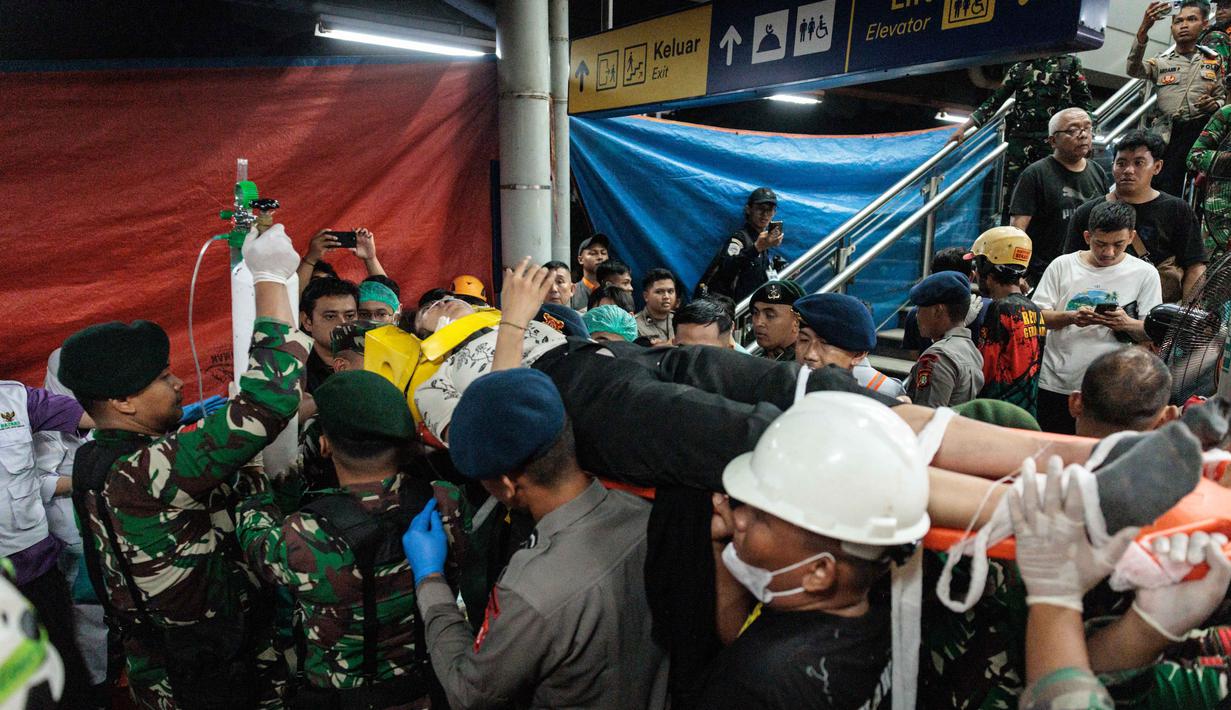 Tim gabungan berupaya mengevakuasi salah satu korban kecelakaan Kereta Api Jarak Jauh (KAJJ) Argo Bromo Anggrek dengan Kereta Rel Listrik (KRL) Commuter Line di stasiun Bekasi Timur, Bekasi, Jawa Barat pada Selasa 28 April 2026. (Yasuyoshi Chiba/AFP)